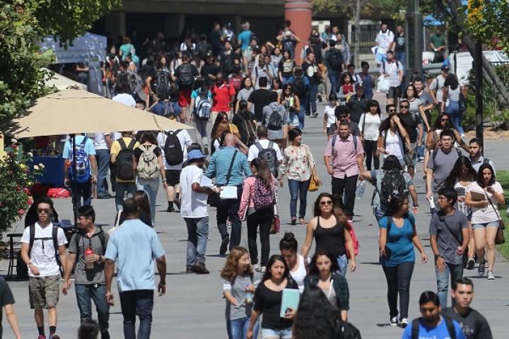 University Walkway showing the Library in the background. Students are walking aournd.